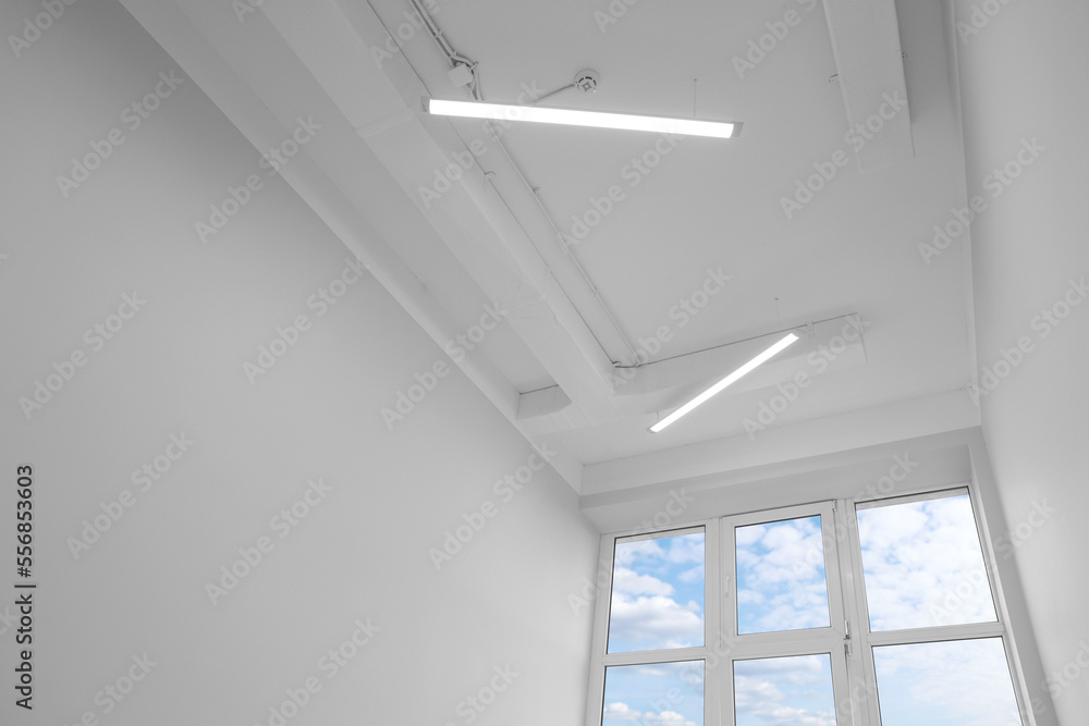 Poster ceiling with modern lights in renovated room