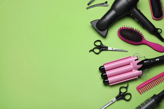 Flat lay composition of professional hairdresser tools on light green background, space for text
