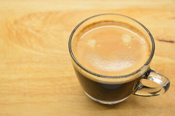 glass of black coffee put on wooden cutting board