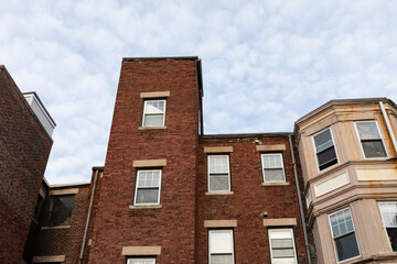 Fototapeta na wymiar Rear view of three different styles of old brick apartment buildings, urban landscape looking up, horizontal aspect