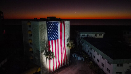 A six-story tall U.S. flag is draped over the side of a building on Fort Myers Beach, FL. that was heavily damaged by Hurricane Ian. 