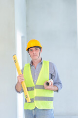 Supervisor male engineer wearing a protective vest and safety hard hat.in construction site for building site survey in civil engineering project.