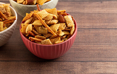 Bowl of Homemade Cereal Nut and Prezel Trail Mix on a Wooden Table