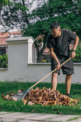 Young man raking leaves