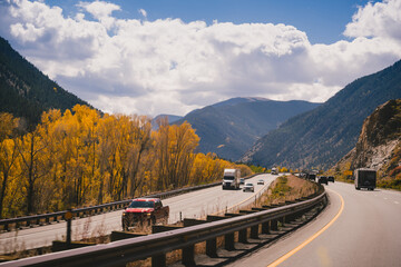 Driving down a highway in the fall through the Rocky Mountains