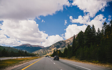 Driving down a highway in the fall through the Rocky Mountains