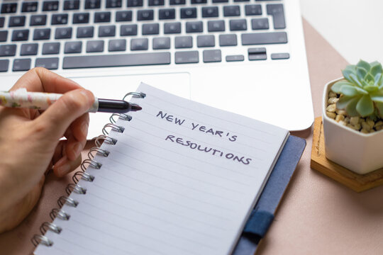 Writing New Year's Resolution With A Black Marker On A Notebook 