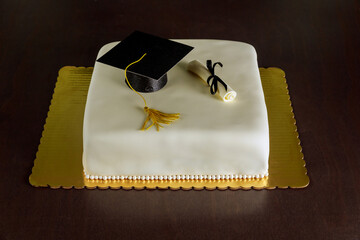 Graduation cake with white fondant and decorations