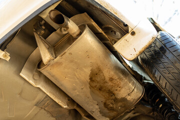 A muffler or silencer of a car. Bottom view of the car.
