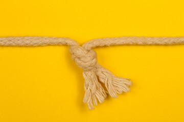 A knot of rope on a yellow background.