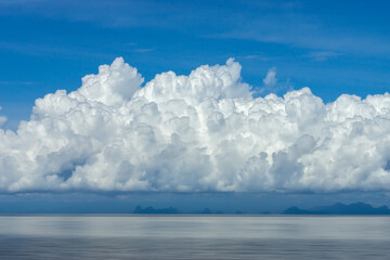 Fototapeta premium A huge white cloud floats above the lake.