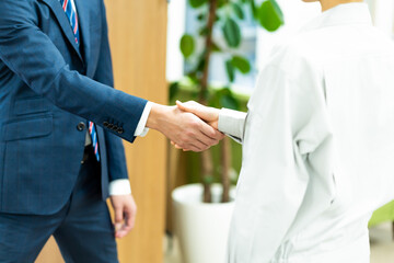 作業服を着た女性とスーツを着た日本人男性