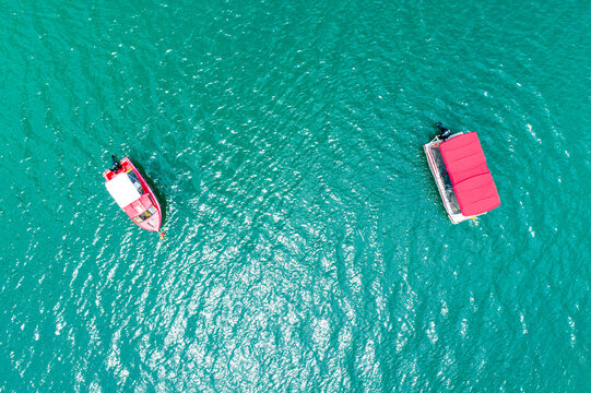 Aerial image of two small boats anchored in estuary.