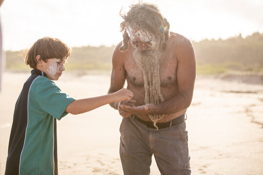 Aboriginal father helping son on a beach