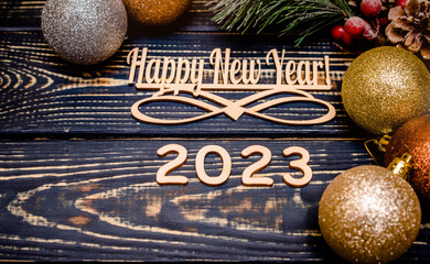 Happy new year 2023 on wooden brown background
