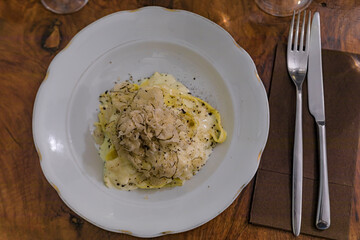 Fresh pasta with truffle in pecorino cheese wheel in restaurant, Florence, Italy