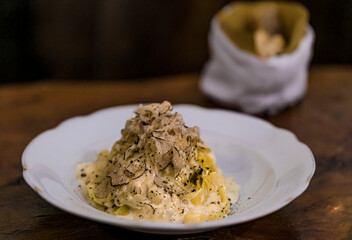 Fresh pasta with truffle in pecorino cheese wheel in restaurant, Florence, Italy