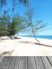 Wooden desk table top and blur tropical beach nature of the background illustration 