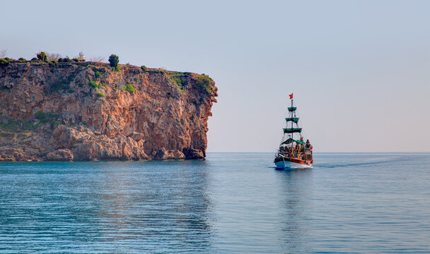 White motorboat on the water of Mediteranean Sea - Cliffs (Falez) in the sea wiev from sea - Antalya, Turkey