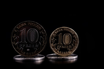 A conceptual story about the inflation of the Russian currency depicting a large 10 ruble coin from 2017 and a small 10 ruble coin from 2022