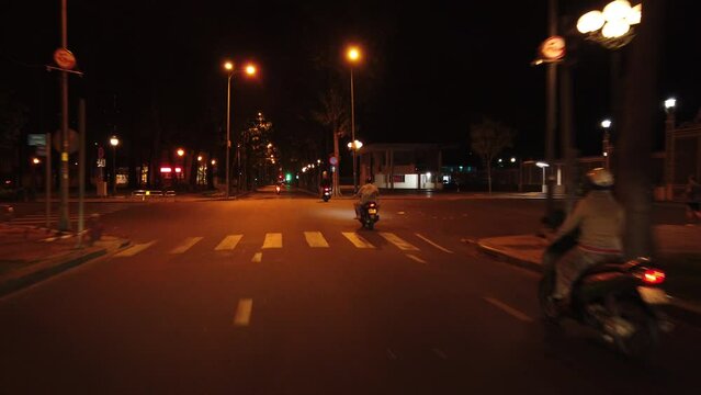 Stabilized dark early morning motorbike ride through the quiet and empty streets of Saigon, Ho Chi Minh City, Vietnam.