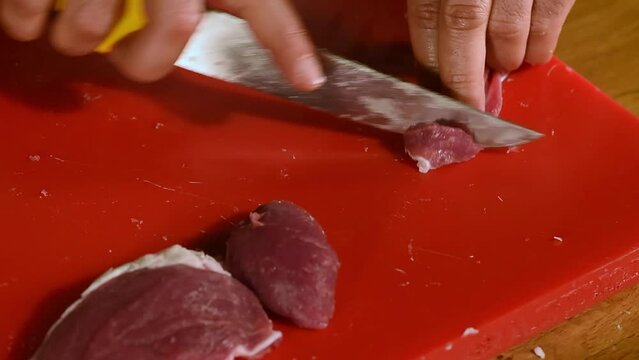 Chef cuts meat into small pieces