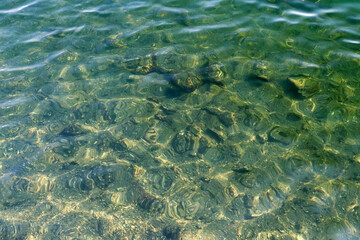 Fototapeta premium Sun shining clear water surface texture photograph.