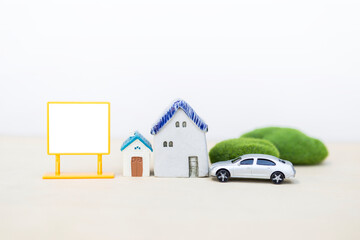 Miniature house and car with blank sign on white background, real estate and property business...
