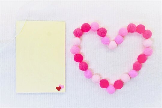 白バックにバレンタインをイメージしたピンク系のハートの形と黄色のメッセージスペースのモックアップ