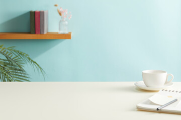 front view of pastel color desk table with offie supplies and cyan background. copy space