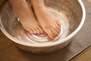エステサロンで足湯で温まる受けるアジア人女性