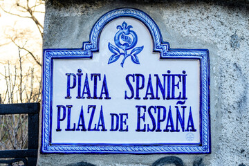 Obraz premium Beautiful vintage street sign showing Piata Spaniei (Spain Square) displayed on an street in the city center of Bucharest, Romania, in a sunny day with clear blue sky