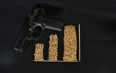 Graphic indicator from grains of wheat on a black background and a gun