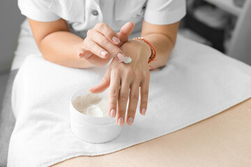 Obraz na płótnie Canvas cold season hands skin protection. closeup woman applying protective cream on hands.