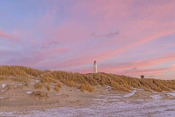 Panorama over the dunes and lighthouse of the Danish coastal resort of Blavand at sunset