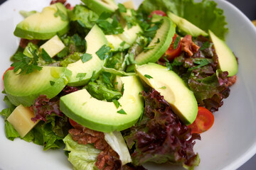 Healthy vegetable salad with avocado and cheese.