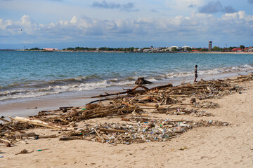 Fototapeta na wymiar Mountains of waste and garbage on the sandy beach after the tide. Humanity is polluting the ocean