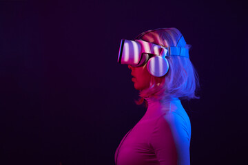 Woman in virtual reality goggle in neon colors.