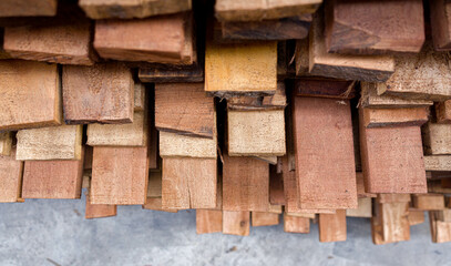 Piles of  Mixed wood  Pine wood  in the sawmill, planking. Warehouse for sawing boards on a sawmill outdoors. Wood timber stack of wooden blanks construction material Industry.
