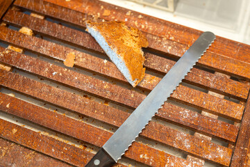 A piece of sliced bread which is placed on wooden cutting board with a knife. Food object photo, selective focus.