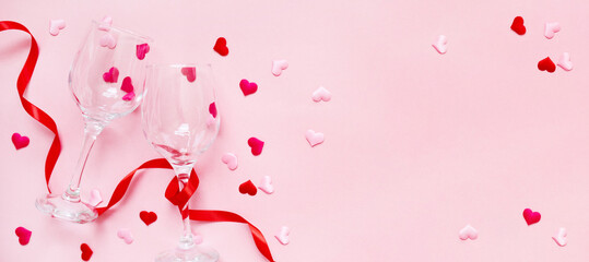holiday background valentine's day. composition withribbons, confetti hearts and glasses on a pink...