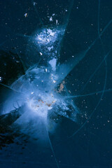 blue ice with white marks and dents from the impact with cracks coming from them with a texture in the winter in the afternoon in frost