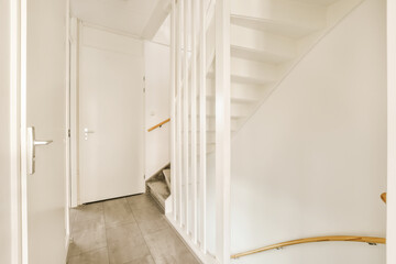 a hallway with white walls and wooden stairs leading up to the second floor in an apartment or...
