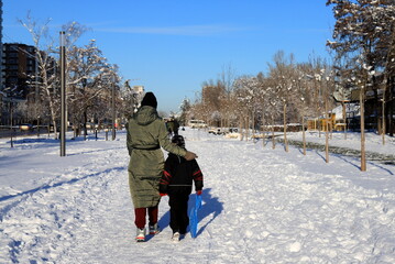 People walk in winter along snow-covered street Winter sports and recreation in city Dnipro, Ukraine