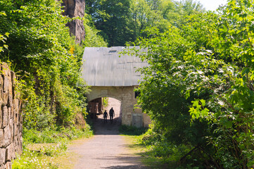 two hikers passing gate on fine summer spring day in Liebethaler Grund Saxonian Switzerland