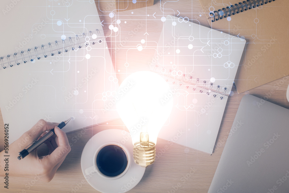 Poster bulb hologram over hands taking notes background. concept of idea. double exposure