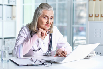 old female doctor working at her cabinet