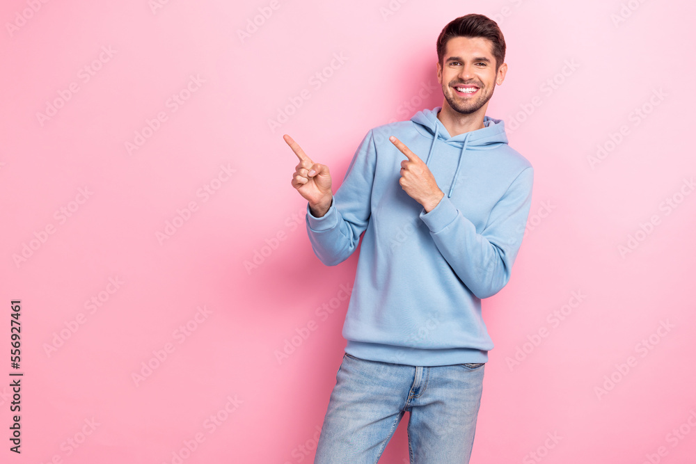 Sticker photo of excited cheerful guy dressed blue sweatshirt pointing two fingers empty space isolated pink