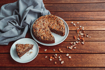 Chocolate hazelnut cake on a white plate with a grey kitchen cloth in the background