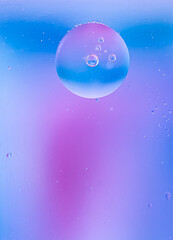 Abstract background in blue and lilac tones. Distortion in water with oil drops.